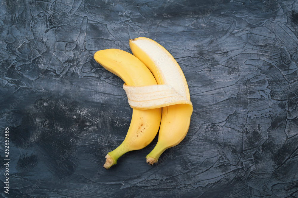 Two bananas isolated on dark background - obrazy, fototapety, plakaty 