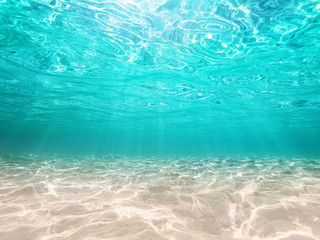 underwater turquoise background deep blue sea and beautiful light rays with sandy floor