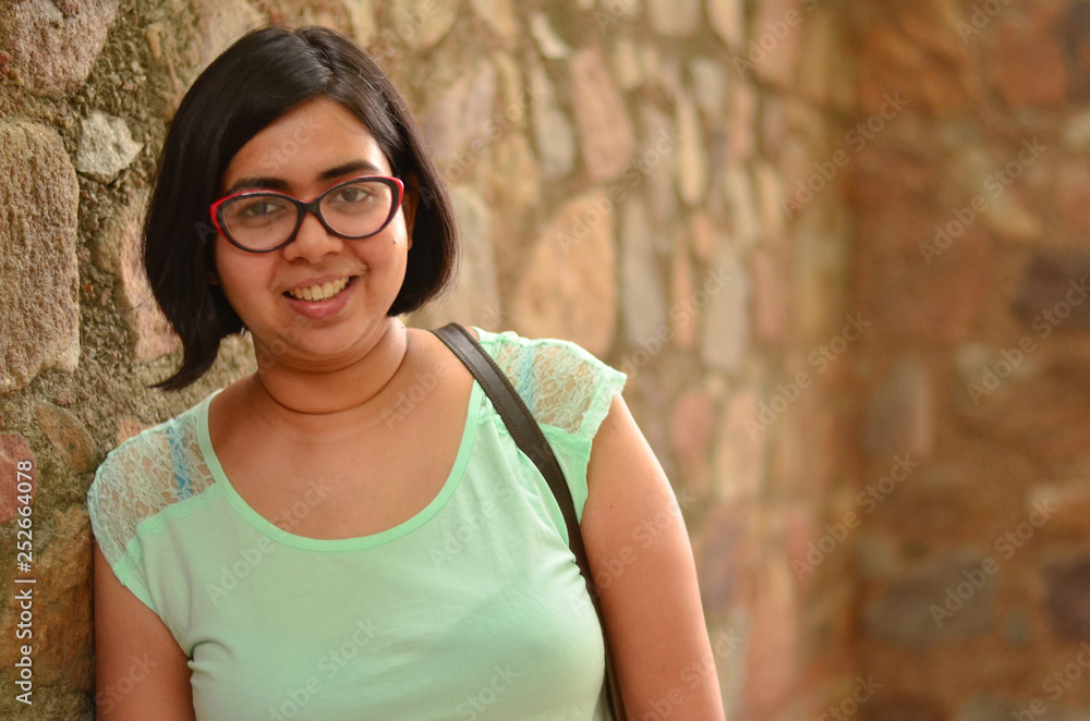 portrait of a young confident indian woman wearing specs standing ...