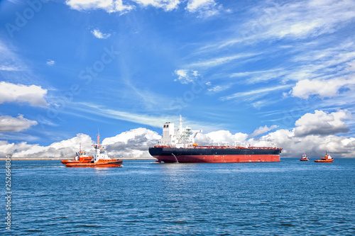 Cuadros en Lienzo Tanker ship with escorting tugs leaving port.