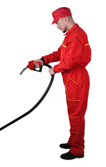 Wall Mural - Man gas station staff  is holding red gasoline pistol pump fuel nozzle