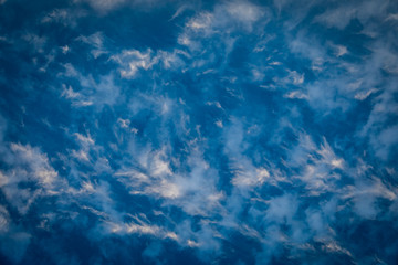 Poster - Close up abstract of deep blue sky with wispy white clouds forming a pattern like waves or sand