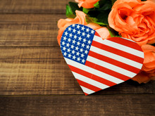 USA Flag In The Form Of Hearts And Flowers On A Wooden Background