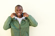 smiling african american man with jacket posing by wall