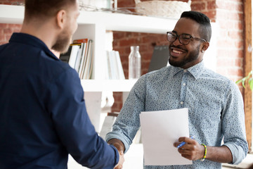 Canvas Print - Black executive manager greeting company client starting business meeting