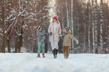Cute Children Boy And Mother Playing In The Winter. Happy Kids Outdoors