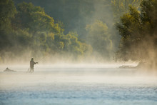 Men Fishing In River With Fly Rod During Summer Morning. Beautiful Fog.