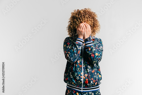 Unrecognizable Man In Modern Tracksuit With Flowers Hidng Face With Hands Indoor Emotional Portrait Of Unknown Male Depressed Crying Person Isolated On White Guy Feeling Shame Regret Repentance Buy This Stock adobe stock