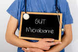 Fototapeta Perspektywa 3d - Doctor shows information on blackboard: GUT Microbiome.  Medical concept.
