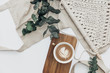 Flat lay Cup of coffee on wooden serving tray and eucalyptus branch with macrame decoration. Minimal bohemian lifestyle concept for blog and social media