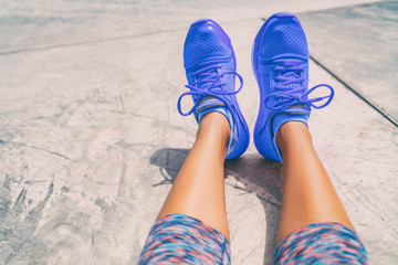 Running shoes fashion activewear healthy active people lifestyle. Selfie woman taking pictures of royal blue trainers during workout at gym floor outside.