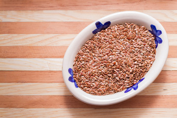 Wall Mural - flaxseed grains in bowl on wooden