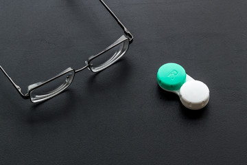 Poster - Eye problems. Glasses with transparent lenses and contact lenses on black background space for text