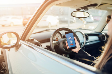 Girl using smartphone app to pay for the parking.