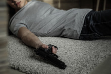 Body Of Man With Gun After Committing Suicide Lying On Floor