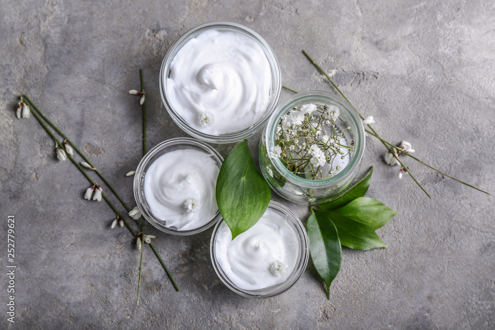 Bowls with natural cream on grey background
