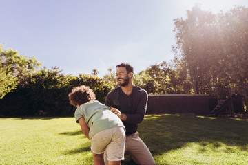 Wall Mural - Man playing with his son in the park