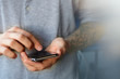 © sipcrew - Male tattoo hands are typing in the phone