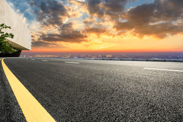 Asphalt road through the modern city above in Shanghai at sunset