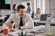© Drazen - Smiling businessman using laptop and reading something on the Internet during lunch break at work.