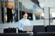 © Seventyfour - Portrait of young businesswoman using laptop while waiting in airport lobby, copy space