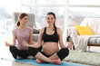© Pixel-Shot - Doula with pregnant woman meditating at home