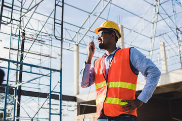  engineer holding radio and ordering at construction working site