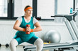 © LIGHTFIELD STUDIOS - attractive overweight girl squatting with dumbbell in gym