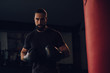 © sasamihajlovic - Boxer with gloves standing by the heavy bag