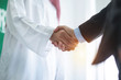 Arabian businessman hands shaking with Asian businessman in office, business concept
