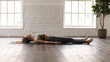 Woman practicing yoga, lying in Savasana, Dead Body pose