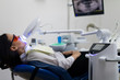 © F8  \ Suport Ukraine - Portrait of young woman visiting dentist office for teeth whitening with photopolymer. Dental care.