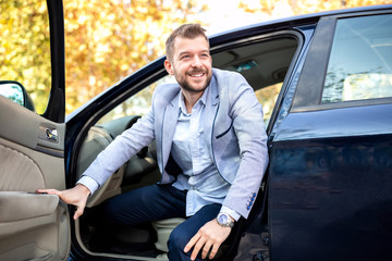 Wall Mural - Charming young man getting out of his car