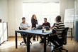 © Flamingo Images - Smiling group of designers working together around an office tab