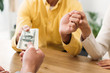 © LIGHTFIELD STUDIOS - cropped view of advisor giving dollar banknotes to investors at table in office
