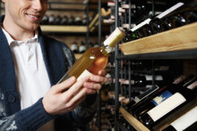 Will Work For Cooking Too! Cropped Portrait Of A Man Shopping Wine Holding A Bottle Smiling Cheerfully