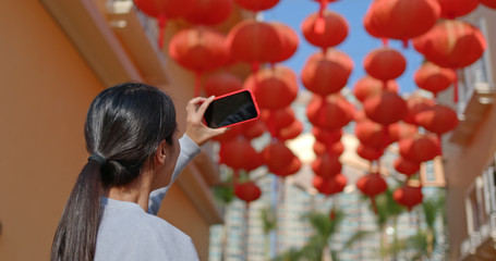 Poster - Woman take photo on cellphone under red lantern