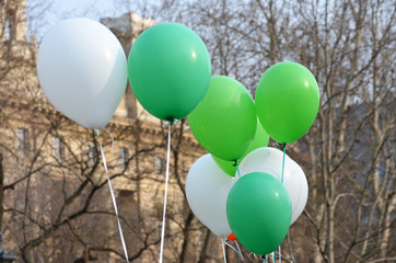 Group of green and white balloons at a St Patrick's Day parade in Budapest city, Ireland traditional celebration