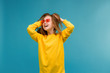 © Tina kids photo - young girl in yellow clothes on blue background,concept of happiness,Portrait of pretty young woman in red sunglasses heart shape smiling, develop hair, blue background