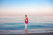 © Александра Голубцова - pretty girl dressed in bright color swim-suit stand on the sea beach in the morning
