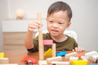 © yAOinLoVE - Cute little Asian 2 - 3 years old toddler boy child having fun playing with wooden building block toys indoor at play school / nursery / daycare / home, Educational toys for young children concept