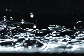 Water droplet splash backgound texture isolated on black. Fresh clean pure water ripples and splashes.  