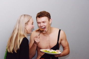 couple embracing and smiling at camera while holding a cup of coffee in kitchen. Smiling young couple at home Adult loving couple gentle and embracing