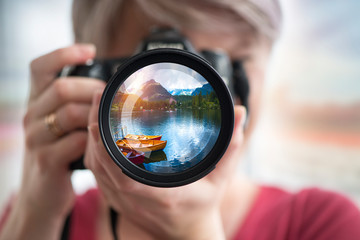 Outdoor travel lifestyle woman photographer shooting video camera at Alaska background. USA vacation holiday in Autumn.