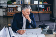 © Pixel-Shot - Mature architect working with drawings in office