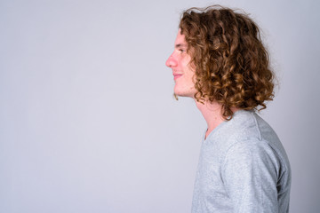 Wall Mural - Closeup profile view of young handsome man with curly hair