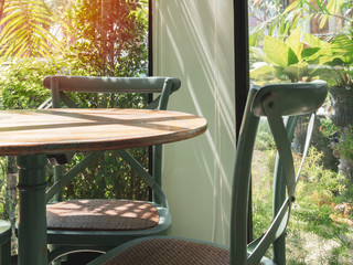 Vintage wooden table and chair in glass room near the garden