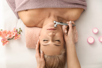 Wall Mural - Mature woman receiving face massage in beauty salon