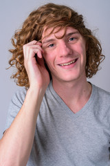 Wall Mural - Face of happy young handsome man with curly hair smiling