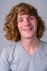 Wall Mural - Face of happy young handsome man with curly hair smiling